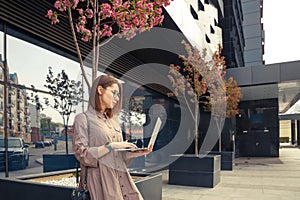 Business woman with computer on the background of a modern building