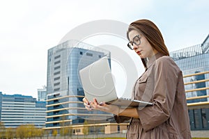 Business woman with computer on the background of a modern building