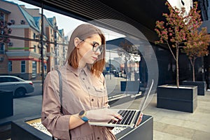 Business woman with computer on the background of a modern building