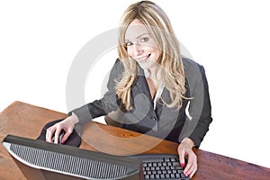 Business woman at computer isolated on white