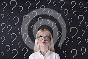 Business woman with Confusion question marks on the blackboard