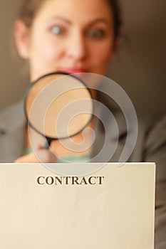 Business woman with contract and loupe