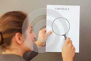 Business woman with contract and loupe