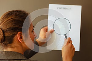 Business woman with contract and loupe