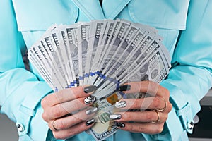 Business woman counting money in hands. Handful of money. Offering money. Women`s hands hold money denominations of 100 dollars.