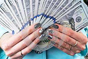 Business woman counting money in hands. Handful of money. Offering money. Women`s hands hold money denominations of 100 dollars.