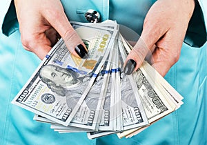 Business woman counting money in hands. Handful of money. Offering money. Women`s hands hold money denominations of 100 dollars.