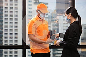 Business woman digitally signing for the received package from online order from delivery man in the urban company office