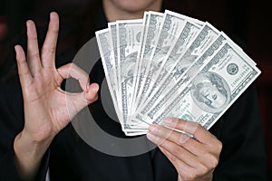 Business woman displaying a spread of cash over, spending money or profit from business operations concept photo