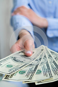 Business Woman Displaying a Spread of Cash US dollars. Close-up. Income and Business concept. Venality, bribe