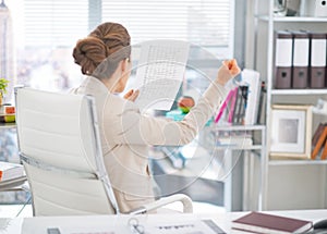 Business woman with document rejoicing at work