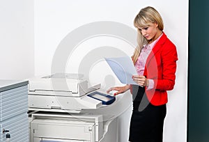 Business woman with documents standing next to printer