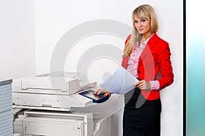 Business woman with documents standing next to printer