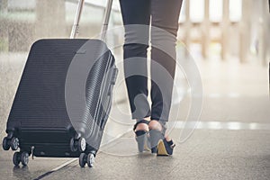 Business woman  Dragging suitcase luggage bag,walking to passenger boarding in Airport.Working young woman travel to work.Asian