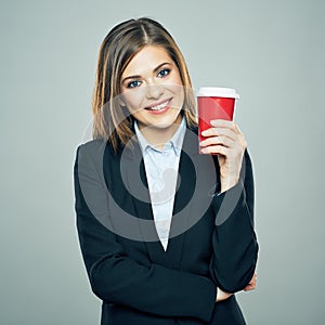 Business woman dressed offise style suit smiling and hold red c