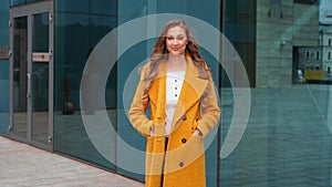 Business woman dressed yellow coat standing outdoors corporative building background ready handshake greeting client