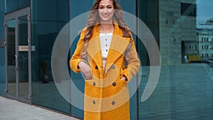 Business woman dressed yellow coat standing outdoors corporative building background ready handshake greeting client