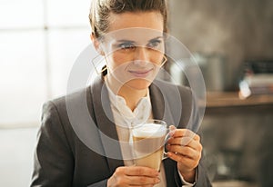 Business woman drinking coffee in loft apartment