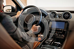 Business woman driving a car. Rear view of hands and steering wheel.
