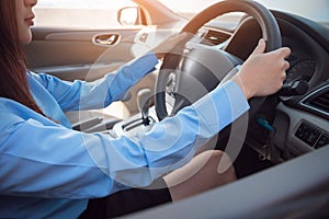 Business woman driving her car, hands holding steering wheel