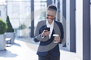 Business woman enjoys cellphone fun and smiling, African American boss businesswoman outside office in business suit