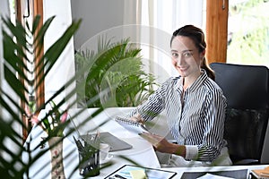 Business woman entrepreneur sitting in bright office and working in internet with laptop computer.