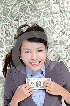 Business woman excited lying on money bed