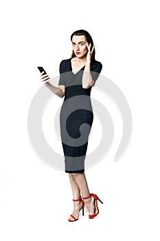 Business woman fatal woman in a black dress with red lipstick talking on the phone, isolated on a white background