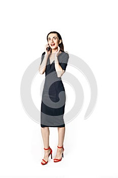 Business woman fatal woman in a black dress with red lipstick talking on the phone, isolated on a white background