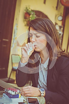 Business woman with flue working at cafe.