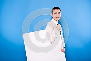 Business woman in formal wear with white panel on blue background