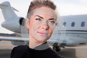 Business woman in front of a corporate jet