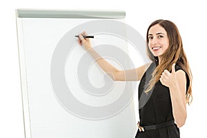 Business woman in front of a white board giving thumbs up