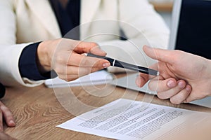 Business woman giving pen to businessman ready to sign contract. Success communication at meeting or negotiation