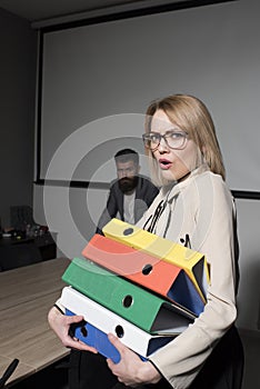 Business woman in glasses hold file folders. secretary with office documents. Surprised woman and bearded man on