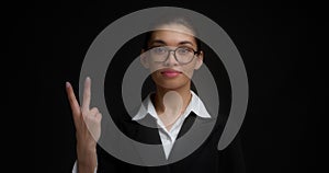Business woman with glasses with a serious face shows two finger.