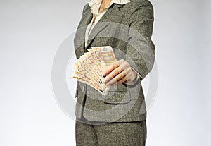 Business woman with gray jacket parses the money fan.