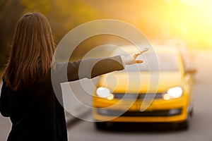 Business woman hand gesture stopping classic yellow taxi