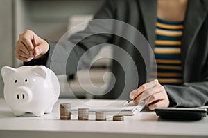Business woman hand holding coins to stack on desk concept saving money finance and accounting