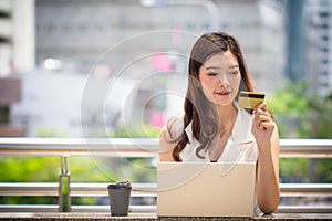 Business woman hand holding credit card using laptop shopping online
