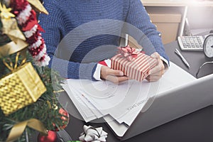 Business woman hand holding gift box on desk office