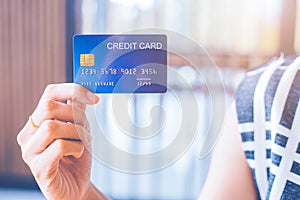 Business woman hand holds a blue credit card