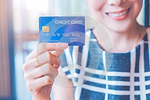 Business woman hand holds a blue credit card