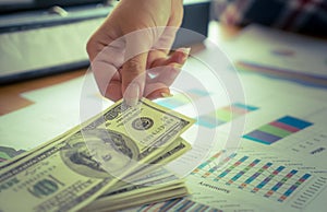 Business woman hand picking up money from desk