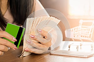 Business woman hand preparing money in hand for payment from credit card form shopping online debt