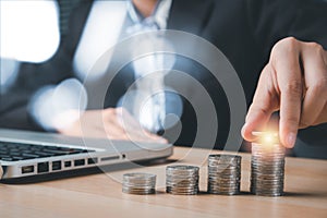 Business woman hand putting money coin stack growing business