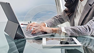 business woman hand typing on laptop computer keyboard with reflection on digital tablet on office table, online working