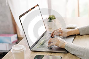 Business woman hand typing laptop computer on wooden table