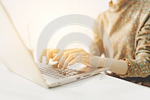 Business woman hand typing on laptop computer working wirelessly portable on cafe table sunny day