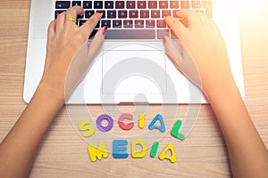 Business woman hand using Laptop pc with social media letters , social media concept